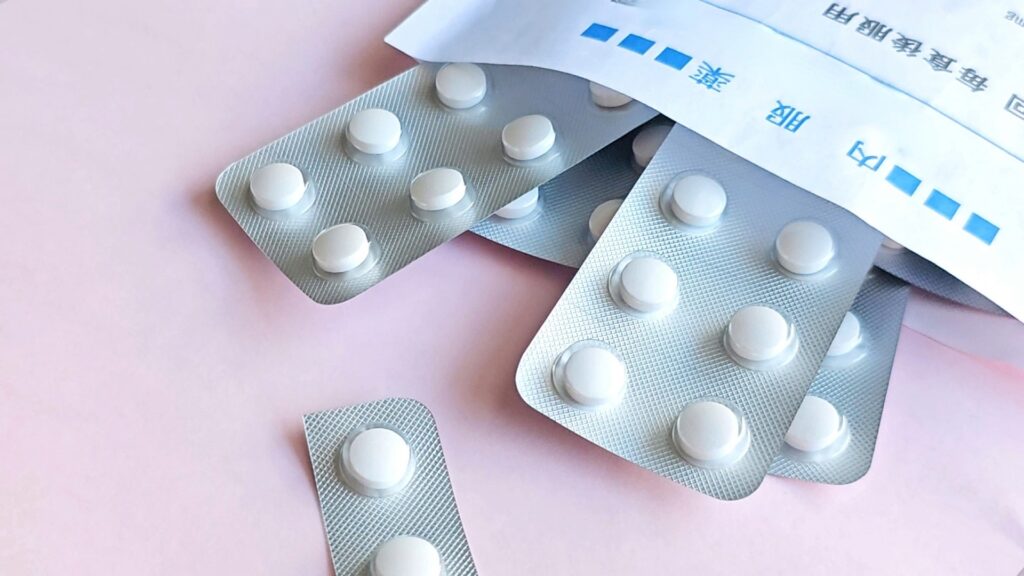 薬剤師の調剤業務から対人業務への移行を象徴する、薬袋から出された白い錠剤とPTPシート。