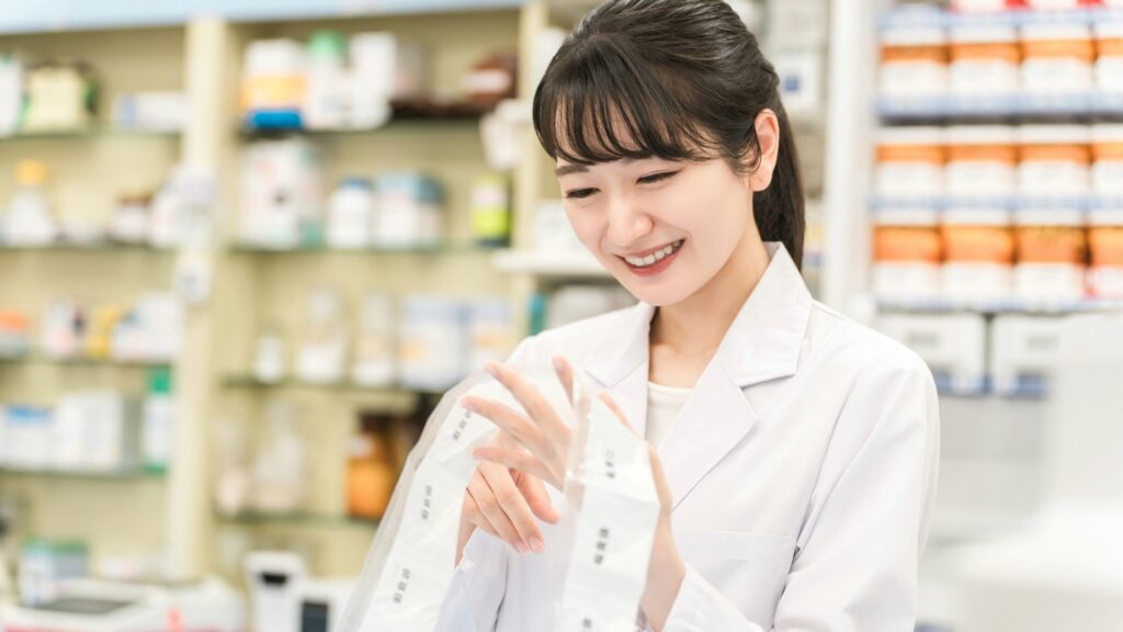 オワコンと言わせない付加価値を提供するため、一包化された薬を丁寧に検品する薬剤師。