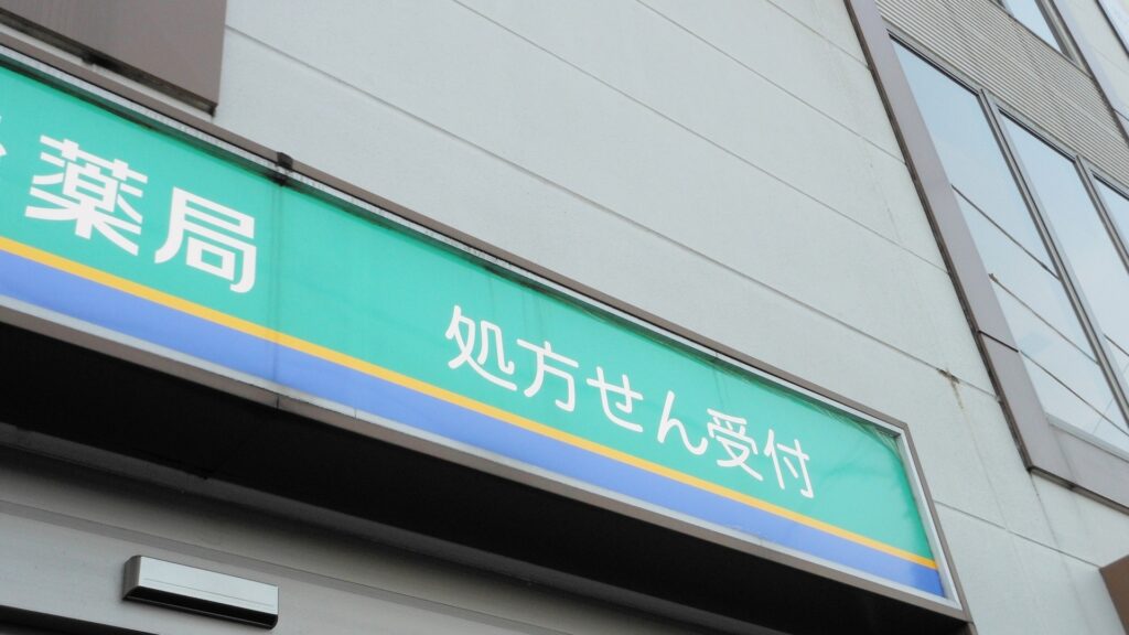 薬剤師の職場である調剤薬局の外観。「処方せん受付」の看板が掲げられた店舗の入り口付近。